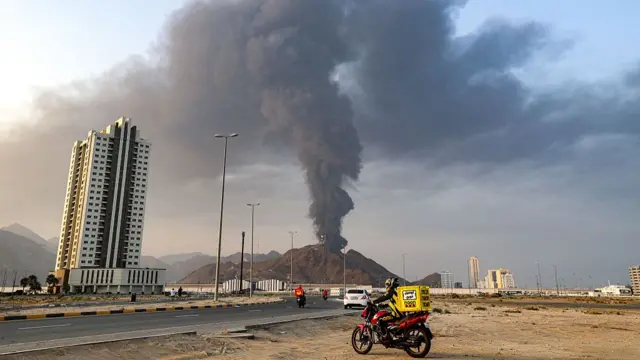 Una alta columna de humo negro que asciende tras una explosión en una zona industrial de Emiratos Árabes Unidos el 3 de marzo de 2026.