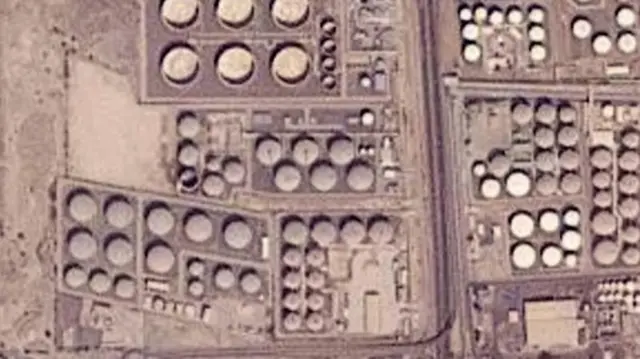O tanque de armazenamento de petróleo danificado, no centro-esquerdo desta imagem de satélite, apresenta marcas de queimadura ao redor e está sem teto
