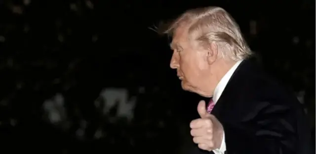 Ifoto ya Trump yambaye ikote ry’umukara ari mu kijima k’ijoro