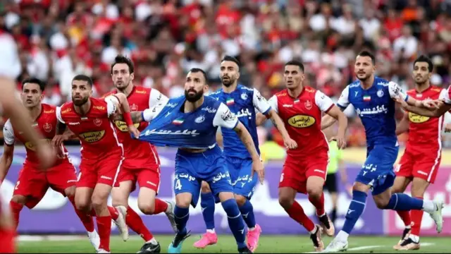 بازیکنان استقلال و پرسپولیس با لباس‌های آبی و قرمز