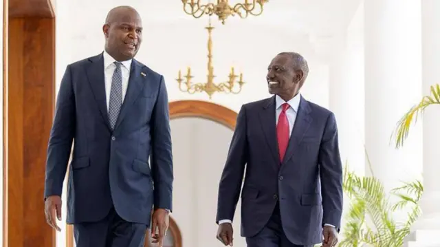 Perezida wa Mozambique Daniel Chapo (ibumoso) na Perezida wa Kenya William Ruto barimo batambuka ku ibaraza barebana, baganira. Bambaye amakositimu yijimye na karuvati.