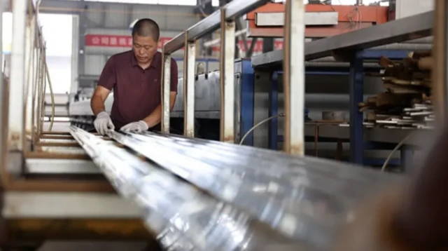 یک کارگر در حال کار در کاخانه تولید آلومینیوم