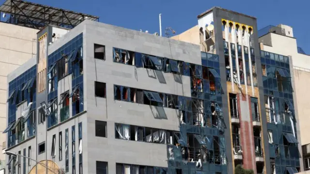 একটি ক্ষতিগ্রস্ত ভবন, যেটির কাঁচের জানালাগুলো ভেঙে গেছে