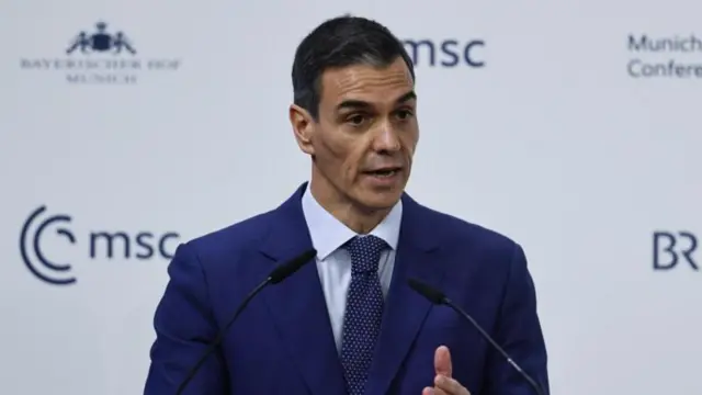 Pedro Sanchez ayakta, üzerinde takım elbiseyle konuşurken