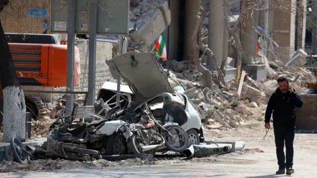 در این عکس بقایای ساختمان و میزان تخریب وسایل نقلیه پس از حمله به مرکز تهران دیده می‌شود