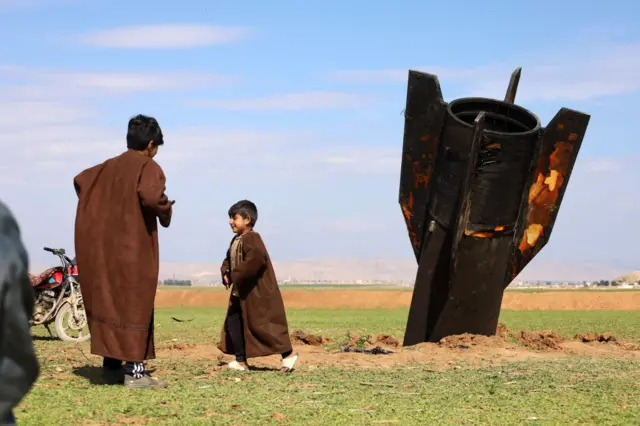 Niños juegan alrededor de un misil