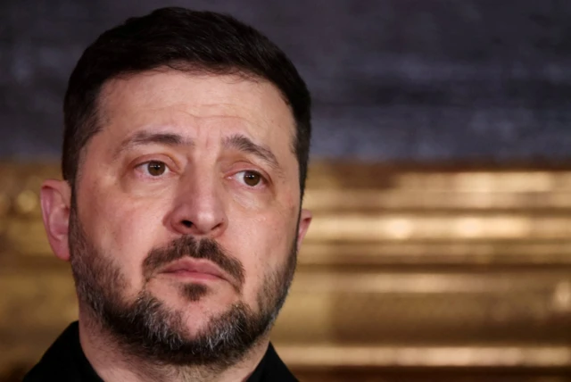 زيلينسكي يبدو حزيناً، وتظهر في الصورة ياقة قميصه ولونها أسود.