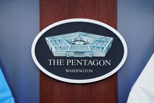 شعار وزارة الدفاع الأمريكية "بنتاغون"، لونه كحلي وعليه رسم المبنى بلون يميل إلى الأزرق وكتب باللغة الإنجليزية بلون أبيض "البنتاغون" و"واشنطن".