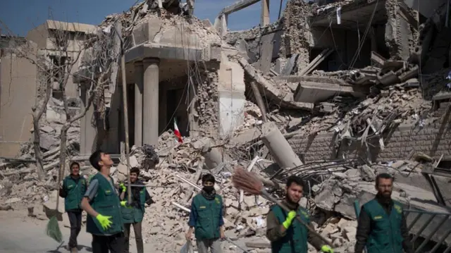 ኢራናውያን በጎ ፈቃደኞች በጥቃት በወደመ የፖሊስ ማዘዣ በኩል ሲያልፉ