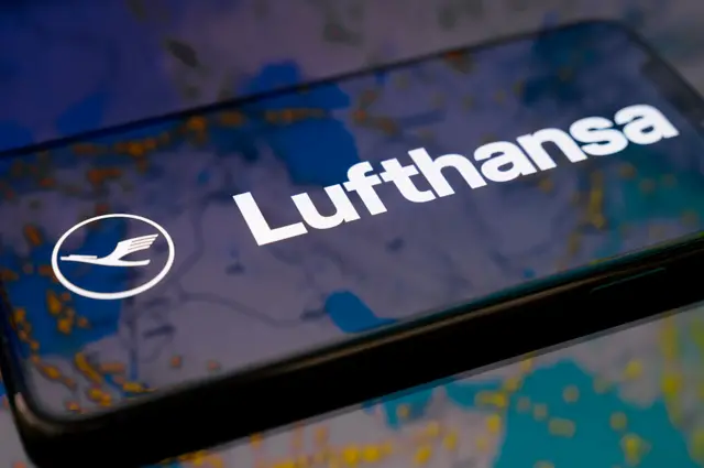 شعار لوفتهانزا على شاشة هاتف ذكي موضوع على سطح عاكس