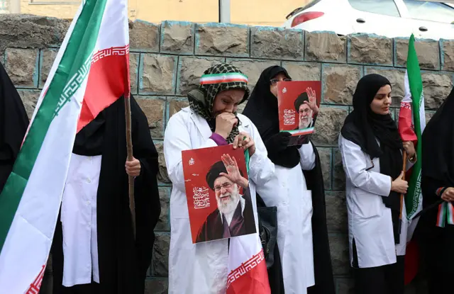 İranlı sağlık çalışanları, 7 Mart 2026'da Tahran'daki yıkılmış Gandhi Hastanesi önünde düzenledikleri protesto sırasında, öldürülen İran dini lideri Ayetullah Ali Hamaney'in posterlerini taşıdılar.