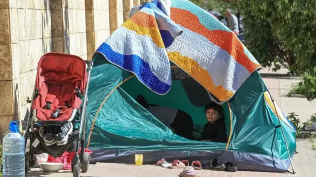 Uma criança deslocada observa o exterior de uma tenda, após uma escalada de tensões entre o Hezbollah e Israel.
