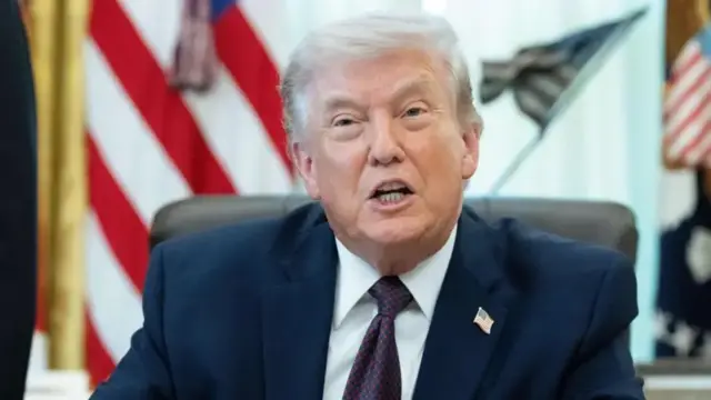 Perezida w'Amerika Donald Trump yicaye mu ntebe y'umusego arimo kuvuga areba muri 'camera'.