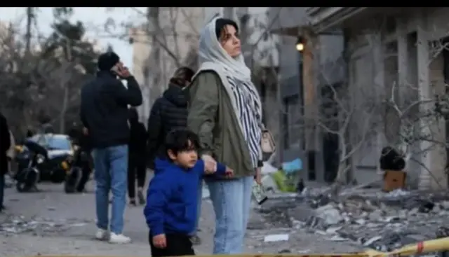 Ifoto: Umugore n’umwana we bareba ibyangijwe n’igitero cy’indege muri Tehran.