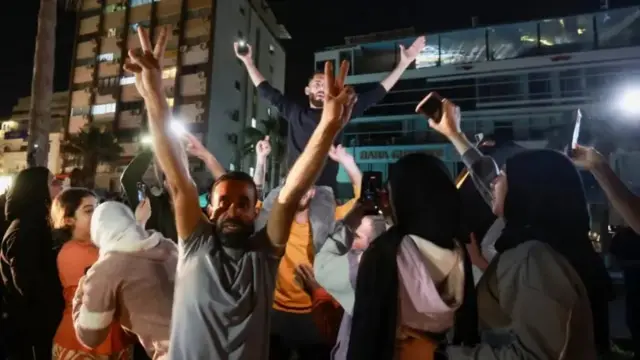 A crowd celebrates in Sidon, Lebanon as displaced people return to their homes after the ceasefire went into effect
