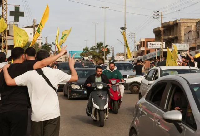 የሄዝቦላህን ባንዲራ የያዙ ሰዎች መንገድ ላይ