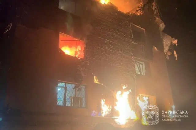 Многоэтажка, в окнах пылает огонь.