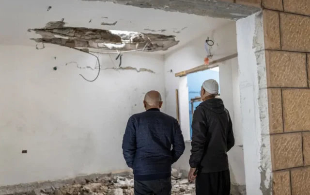 يقوم أفراد من الطائفة الدرزية في مدينة شفا عمرو بجنوب لبنان، بتقييم حجم الأضرار الناجمة عن إطلاق الصواريخ الإسرائيلية.