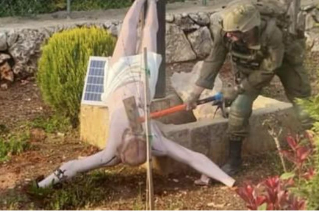 صورة جندي إسرائيلي يحطم رأس تمثال المسيح بمطرقة بعد أن أوقعه على الأرض، التقطها جنود إسرائيليون