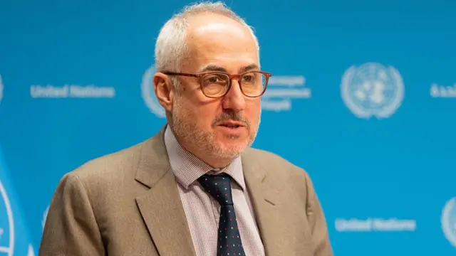 استفان دوجاریک، سخنگوی سازمان ملل، با کت کرم و کراوات سرمه‌ای