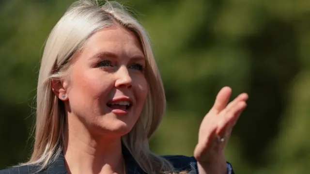 کارولین لویت، سخنگوی کاخ سفید با کت سیاه راه راه