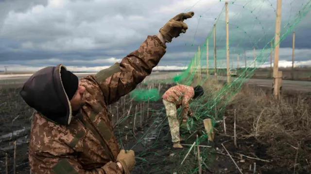 Украинские военные натягивают антидроновую сетку на одной из дорог вокруг Славянска. Именно этот город может стать главной целью российского наступления в Донецкой области