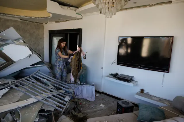 دونا، 38 عاماً، نازحة عادت مؤقتًا إلى منزلها، تنظف شقتها في مبنى تضرر جراء غارة إسرائيلية، وسط وقف مؤقت لإطلاق النار بين لبنان وإسرائيل، في صور، 23 أبريل/نيسان 2026.