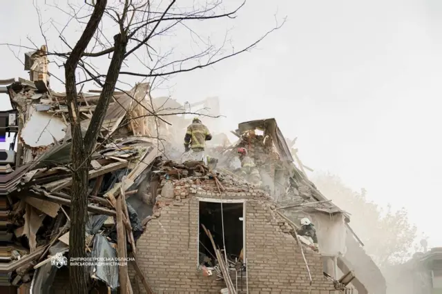 Спасатель на разрушенном доме.