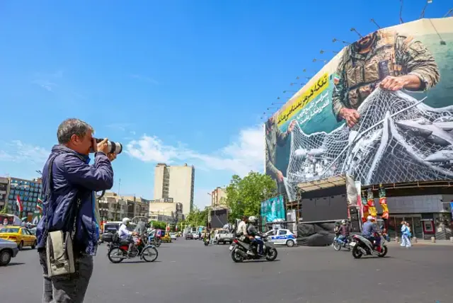 ifoto y'umuntu ariko afotora icapa i Tehran ku murwa mukuru wa Iran