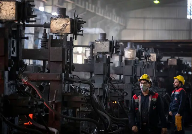 عمال إيرانيون في مجمع كرمان للصلب في مدينة خزرة الصناعية بمحافظة كرمان