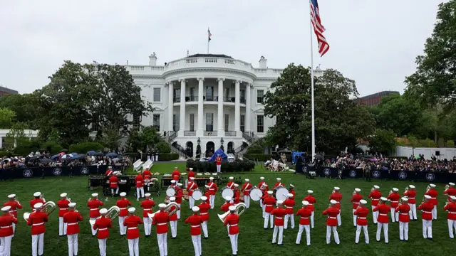 دسته موزیک ارتش در حال نواختن در فضای سبز بیرون کاخ سفید و زیر باران