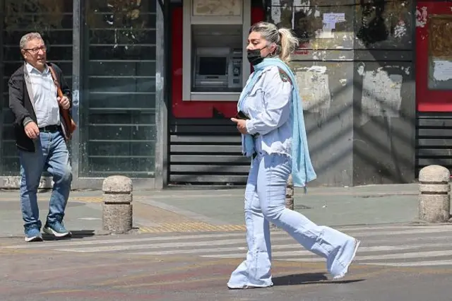 তেহরানের রাস্তায় হেঁটে যাচ্ছেন এক নারী, একজন পুরুষকেও হাঁটতে দেখা যাচ্ছে