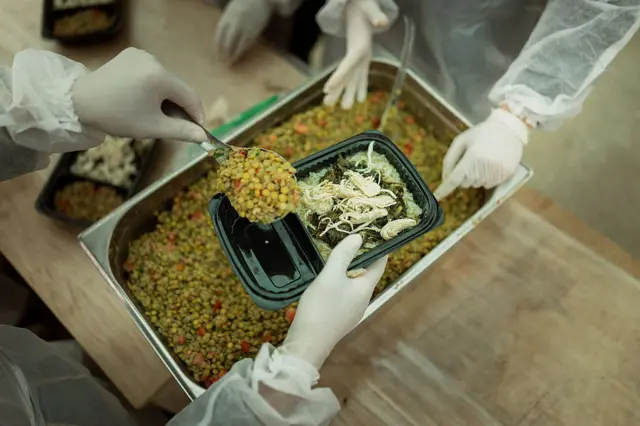 متطوعون يعدون وجبات الطعام في سوق الطيب للنازحين في بيروت