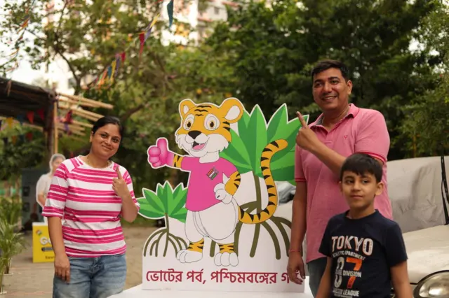 বাবা-মায়ের সঙ্গে বুথের বাইরে এক খুদে।