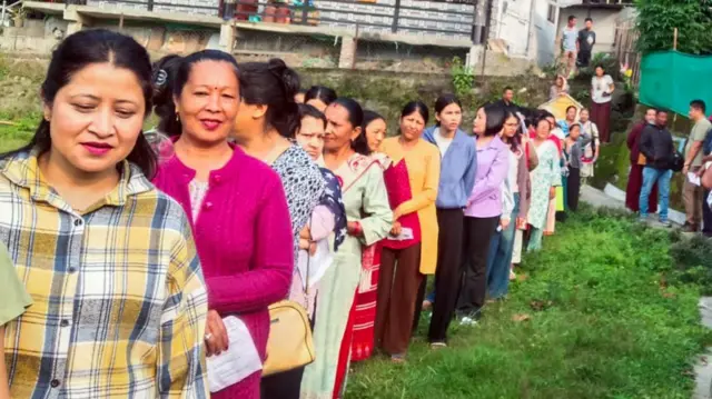 वोटिंग के लिए कतार में लगे लोग