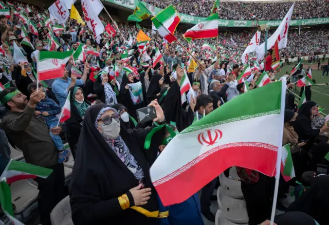جماهير يلوحون بالأعلام الإيرانية في ملعب آزادي لكرة القدم، غرب طهران، في 26 مايو/أيار 2022