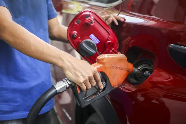 شخص خلال تعبئة سيارته بالبنزين