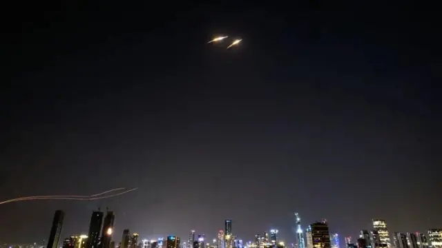 Ibisasu bibiri biri mu kirere ari nijoro, hejuru y'inyubako ndende.