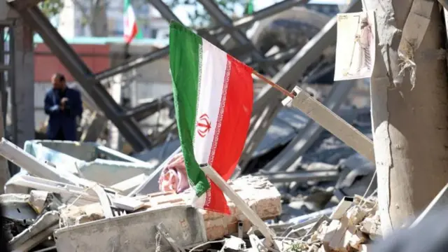 رُفع العلم الإيراني على أنقاض مبنى متضرر في جامعة شريف يوم الثلاثاء.