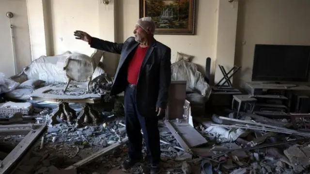 তেহরানের খোরাসানিহা সিনাগগ-এর পাশের একটি ভবনে নিজের ধ্বংসপ্রাপ্ত অ্যাপার্টমেন্টে দাঁড়িয়ে কথা বলছেন এক ইরানি ব্যক্তি।