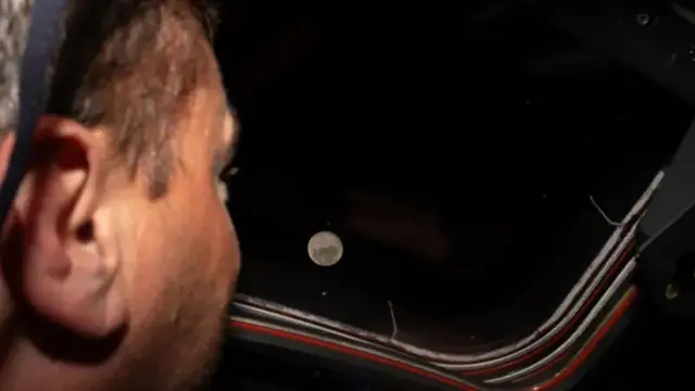 Artemis II commander Reid Wiseman looks out the window of the Orion spacecraft at the Moon