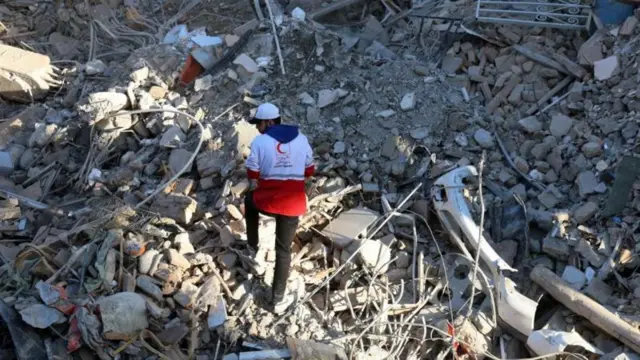 عامل من الهلال الأحمر الإيراني يبحث بين أنقاض كنيس خراسانيها المدمر في طهران