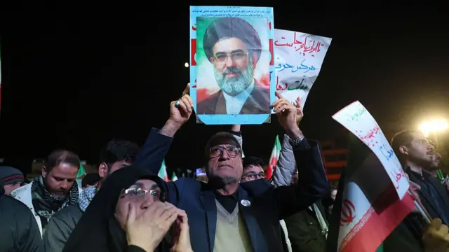 मोजतबा खामेनेई की तस्वीर लिए हुए ईरानी लोग
