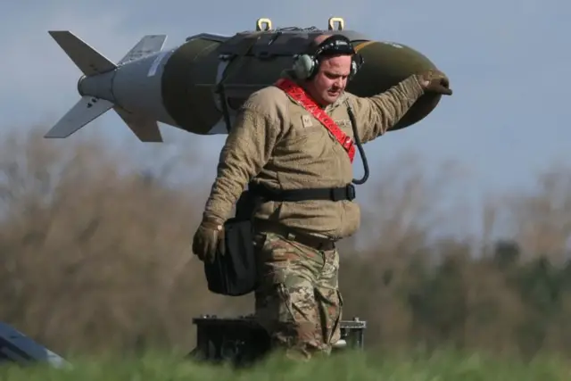 رجل يقف عند شاهد يشبه القذيفة.