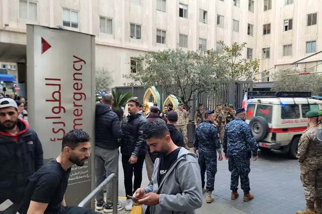 أشخاص يتجمعون أمام مدخل طوارئ في مستشفى وتظهر عربة إسعاف وعناصر أمن وعناصر من الجيش اللبناني