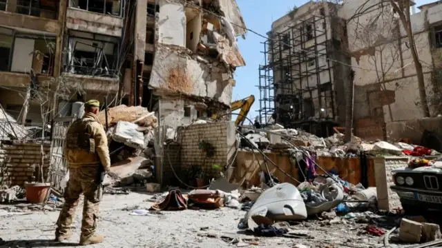 جندي لبناني يقف بجوار مبنى سكني مدمر في بيروت، في اليوم التالي لغارة جوية إسرائيلية