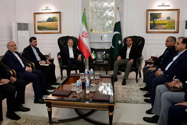 رئيس أركان الجيش الباكستاني، المشير سيد عاصم منير يجلس بصحبة مفاوضين إيرانيين من بينهم وزير الخارجية الإيراني عباس عراقجي لدى وصولهم إلى إسلام آباد، أثناء أول جولة للمفاوضات هناك، ويظهر علما باكستان وإيران في الخلفية.