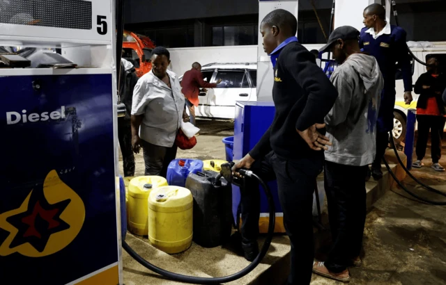 Ifoto : Umukozi wo kw’isitasiyo y’ibitoro ariko asuka igitoro mw'ibido z’umukiriya, mu gihe abatwara imodoka bariko baruzuza ibitoro ku gisata ca Astrol i Ruai hafi ya Nairobi muri Kenya, kw’igenekerezo rya 14 Rusama 2026, mu gihe ibiciro vy’ibitoro biriko biraduga kubera ihungabana ry’isoko mpuzamakungu.