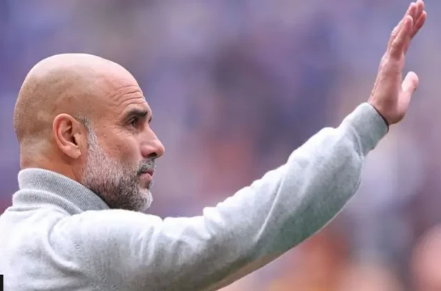 ifoto ya Pep Guardiola azamuye ukuboko nkusuhuza abari kure ye