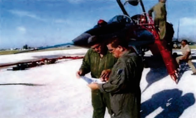 Luis Raúl González Pardo Rodríguez y Lorenzo Alberto Pérez Pérez junto a un avión de combate cubano